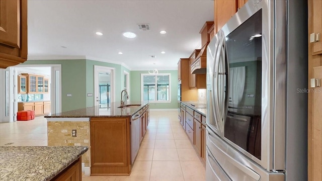 kitchen with stainless steel fridge, a center island with sink, plenty of natural light, and sink