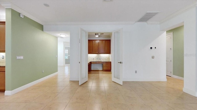 tiled spare room with built in desk and crown molding