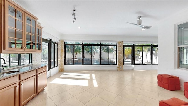 interior space featuring light tile patterned floors, a wealth of natural light, crown molding, and ceiling fan