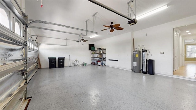 garage featuring electric water heater, ceiling fan, and a garage door opener