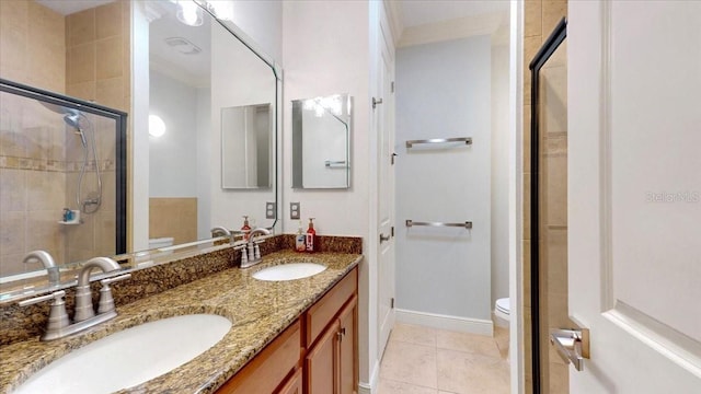 bathroom featuring tile patterned floors, ornamental molding, vanity, toilet, and a shower with shower door