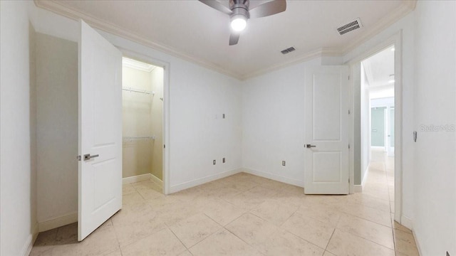 unfurnished bedroom featuring ceiling fan, a walk in closet, ornamental molding, and a closet