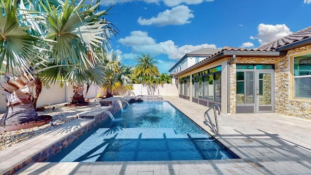 view of swimming pool featuring pool water feature and a patio