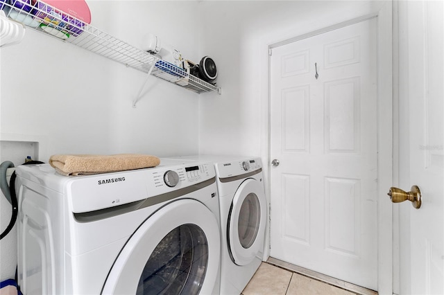 laundry area featuring washer and dryer and light tile patterned floors