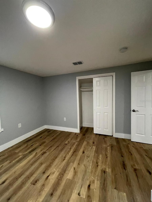 unfurnished bedroom featuring a closet and hardwood / wood-style flooring