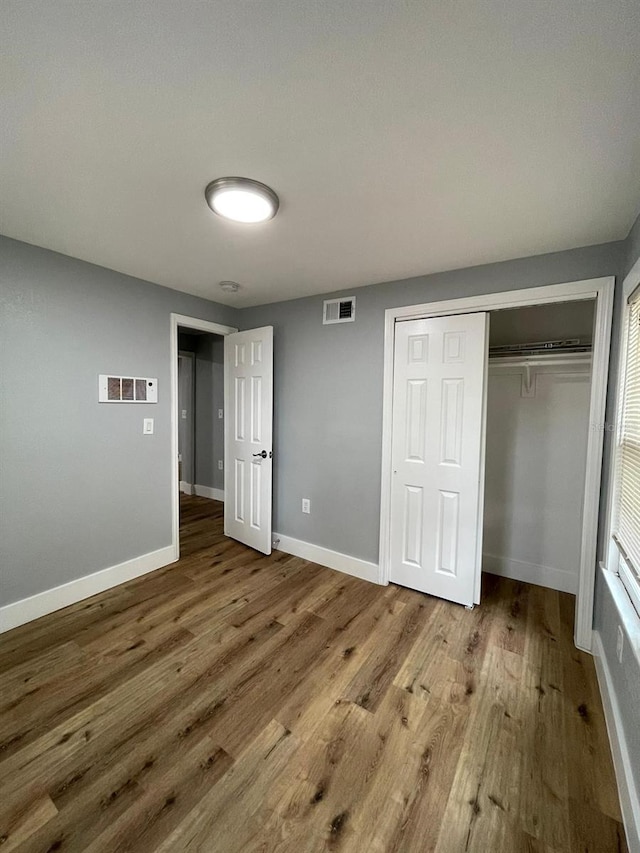 unfurnished bedroom featuring hardwood / wood-style flooring and a closet