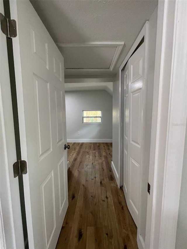 hallway with wood-type flooring and a textured ceiling