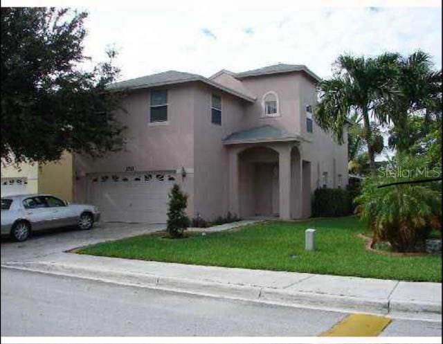 view of front property featuring a garage and a front yard