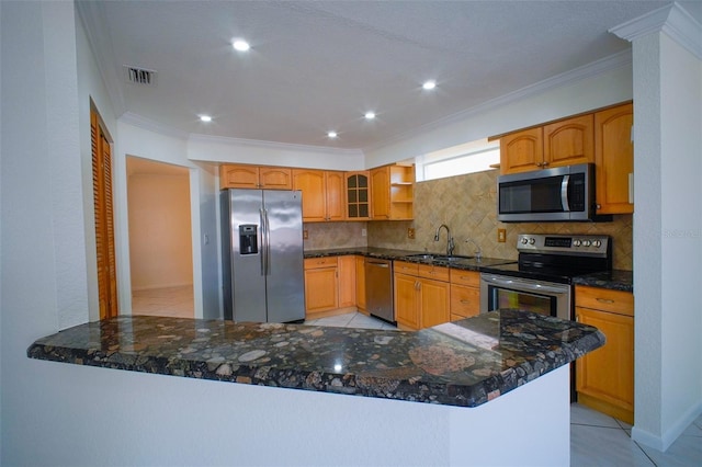 kitchen with kitchen peninsula, crown molding, dark stone countertops, and appliances with stainless steel finishes