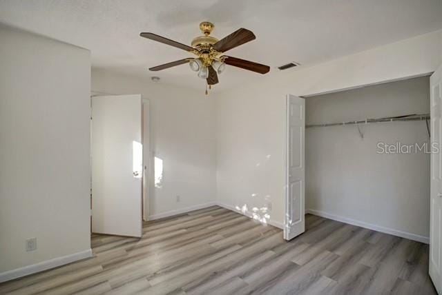 unfurnished bedroom with ceiling fan, a closet, and light hardwood / wood-style flooring