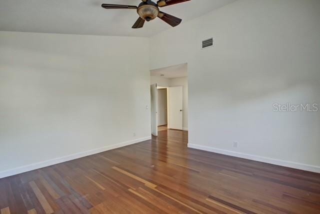 spare room with ceiling fan, dark wood-type flooring, and high vaulted ceiling