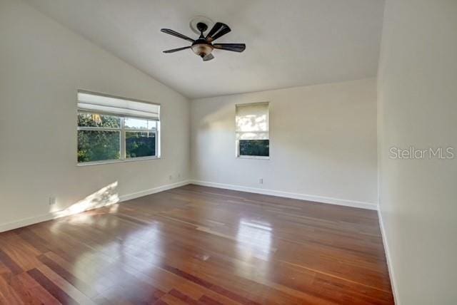 empty room featuring ceiling fan, dark hardwood / wood-style flooring, and vaulted ceiling