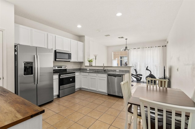 kitchen with sink, a notable chandelier, decorative light fixtures, white cabinets, and appliances with stainless steel finishes