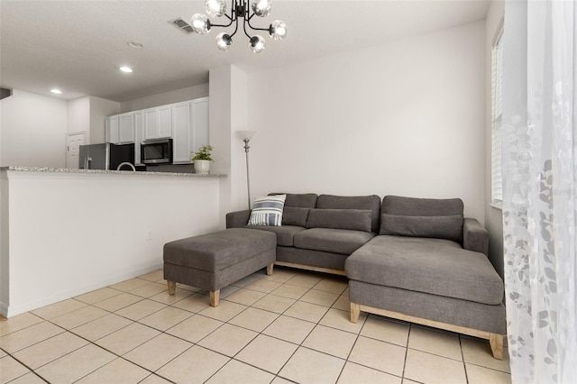 tiled living room featuring a notable chandelier