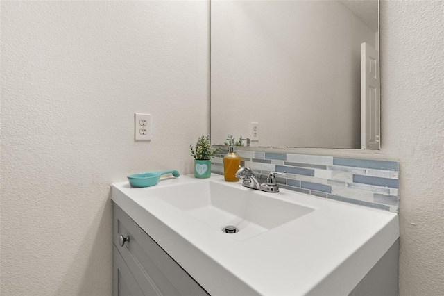 bathroom with vanity and tasteful backsplash