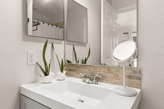 bathroom featuring tasteful backsplash and vanity