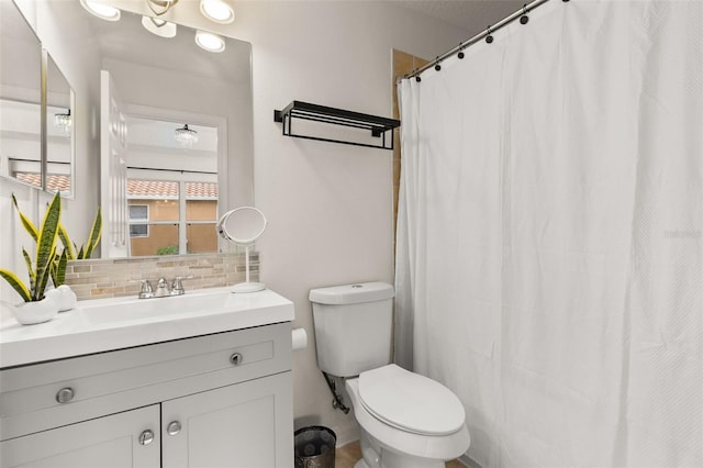 bathroom featuring backsplash, vanity, and toilet