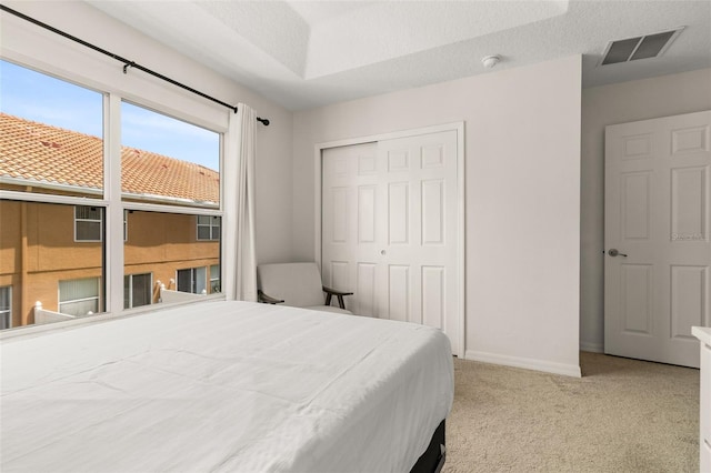 carpeted bedroom with a textured ceiling and a closet