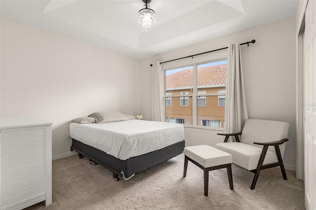 carpeted bedroom with a tray ceiling