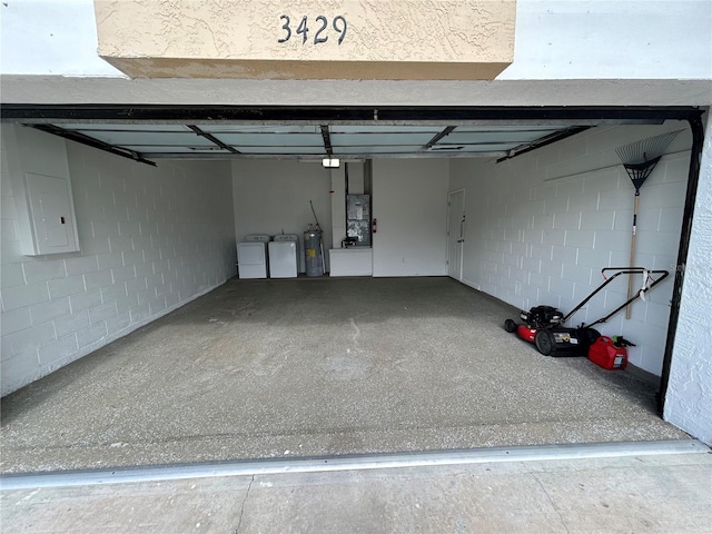 garage with electric panel, separate washer and dryer, and water heater