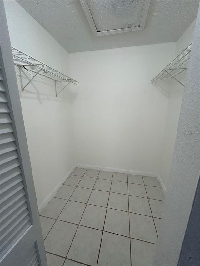 walk in closet with light tile patterned floors