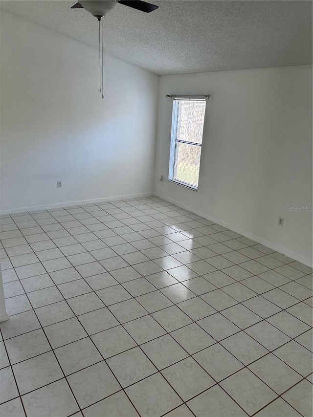 unfurnished room featuring ceiling fan, light tile patterned floors, and a textured ceiling