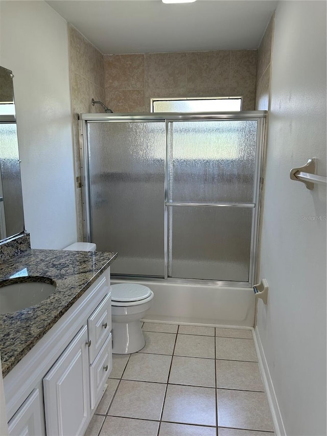 full bathroom featuring tile patterned floors, vanity, bath / shower combo with glass door, and toilet