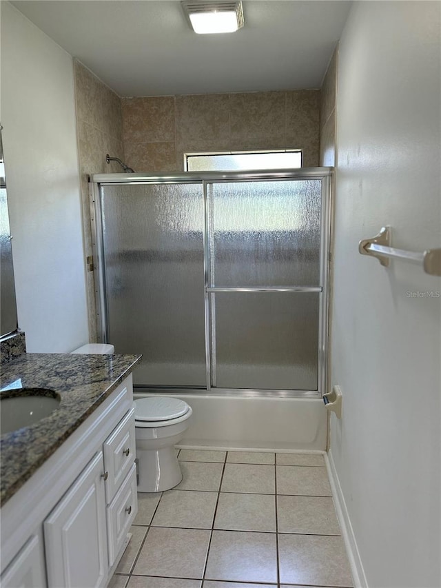 full bathroom featuring tile patterned flooring, vanity, toilet, and enclosed tub / shower combo