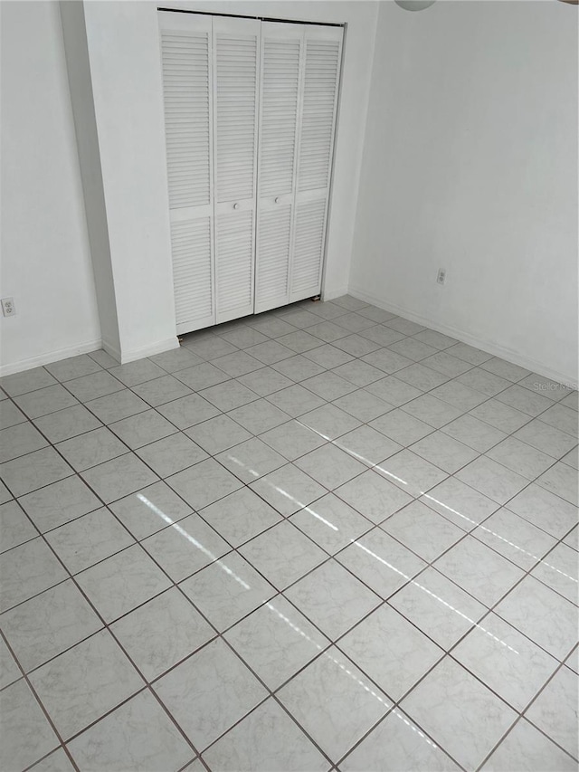 unfurnished bedroom with a closet and light tile patterned flooring