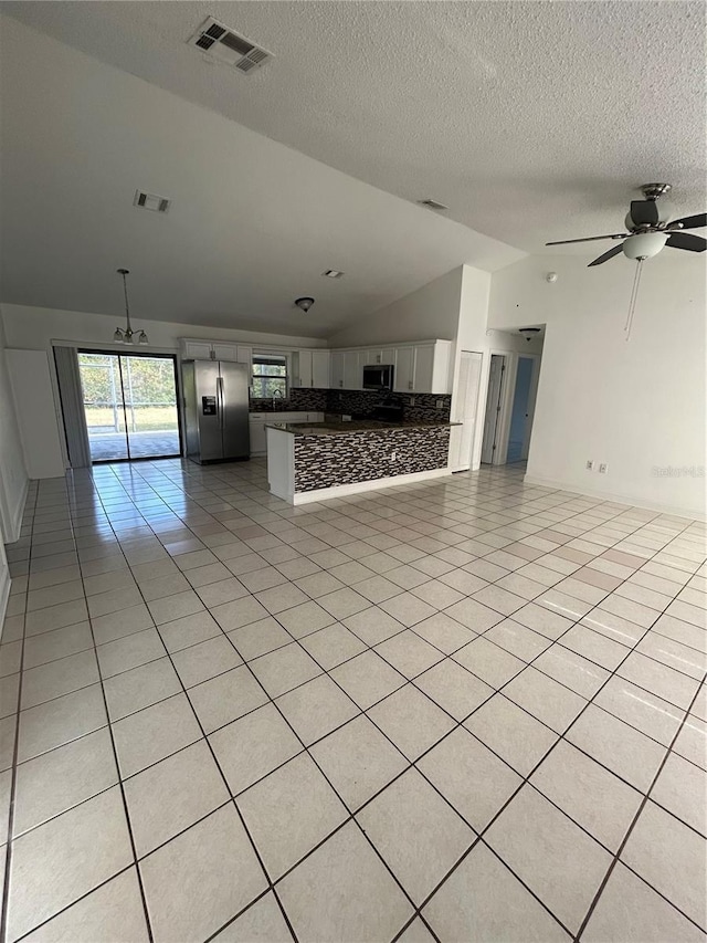 unfurnished living room with ceiling fan, light tile patterned flooring, and high vaulted ceiling