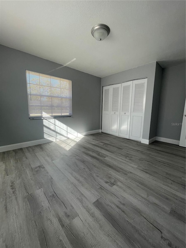 unfurnished bedroom with hardwood / wood-style floors, a textured ceiling, and a closet