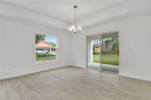 314A Dagama Ct, Kissimmee, FL 34758 - unfurnished room featuring baseboards, a raised ceiling, and an inviting chandelier