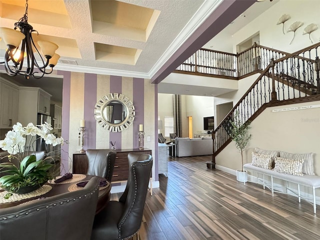 interior space featuring a notable chandelier, dark hardwood / wood-style flooring, coffered ceiling, and ornamental molding