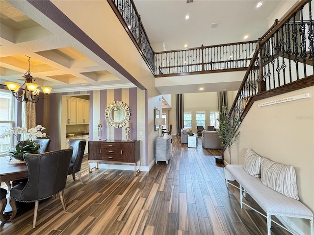 foyer entrance with a chandelier, dark wood finished floors, baseboards, and stairs