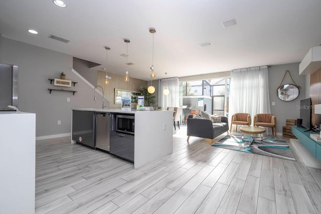 kitchen with pendant lighting, light wood-type flooring, and appliances with stainless steel finishes