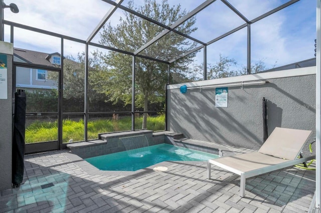 view of pool featuring a patio area, pool water feature, and glass enclosure