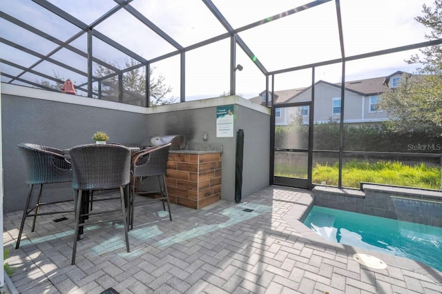 view of patio with a bar and glass enclosure