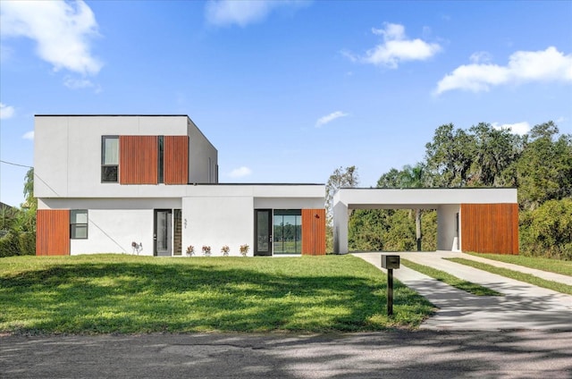 contemporary home featuring a front lawn and a carport