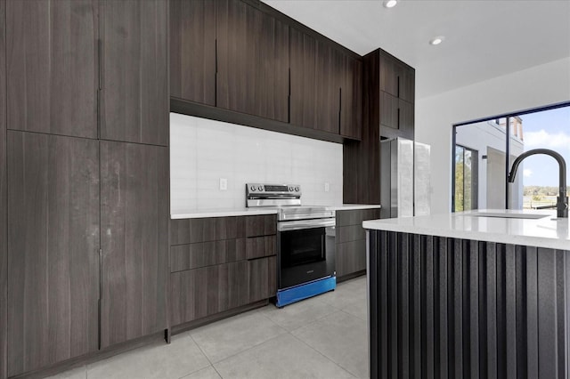 kitchen with sink, decorative backsplash, light tile patterned floors, dark brown cabinetry, and stainless steel appliances