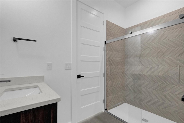 bathroom with tile patterned floors, vanity, and walk in shower