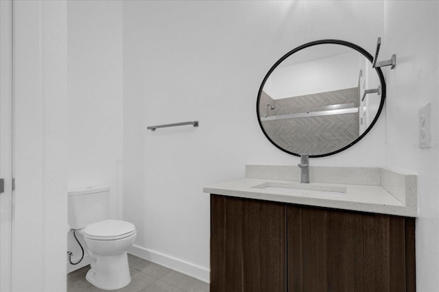 bathroom with tile patterned flooring, vanity, and toilet