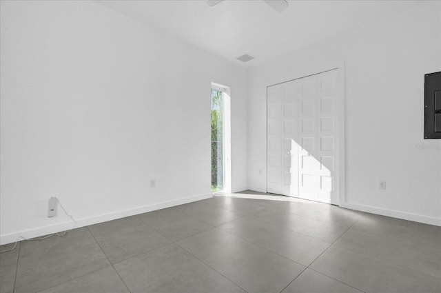 spare room with electric panel and dark tile patterned flooring