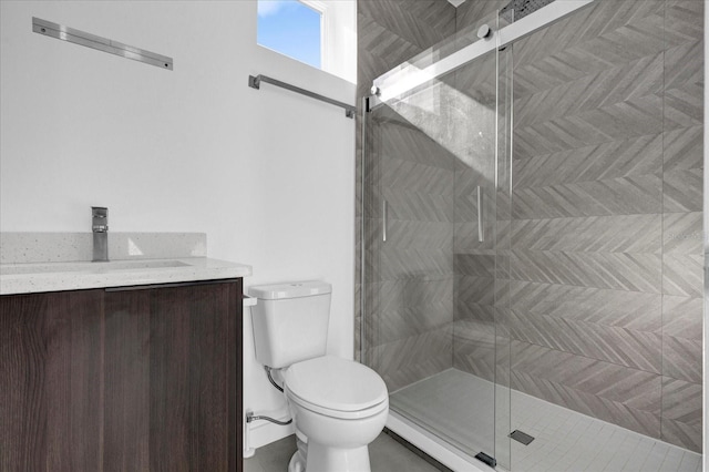 bathroom featuring vanity, an enclosed shower, and toilet