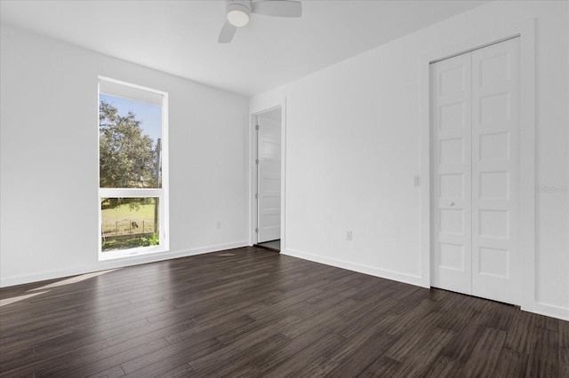 unfurnished bedroom with ceiling fan, dark hardwood / wood-style flooring, and multiple windows