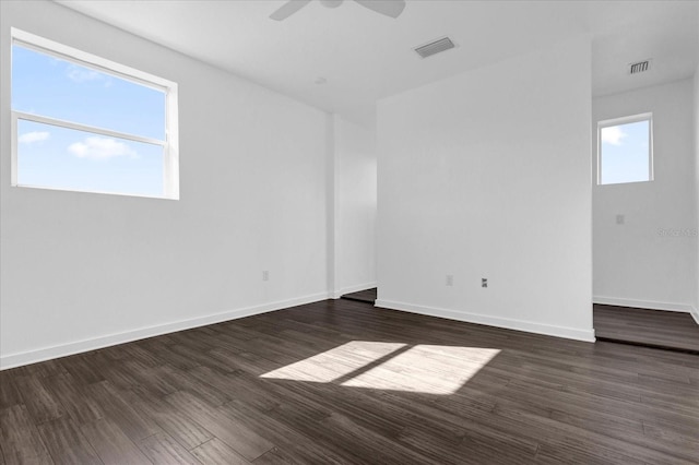 empty room with a wealth of natural light, ceiling fan, and dark hardwood / wood-style floors