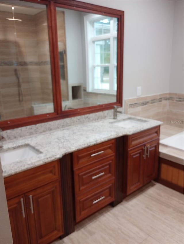 bathroom with vanity and shower with separate bathtub