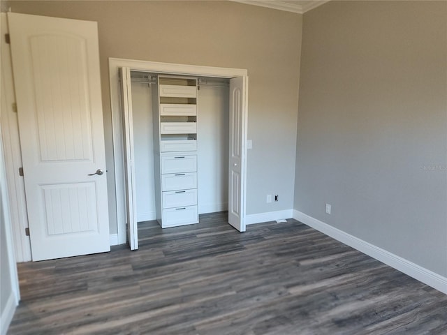 unfurnished bedroom with dark hardwood / wood-style flooring, a closet, and ornamental molding