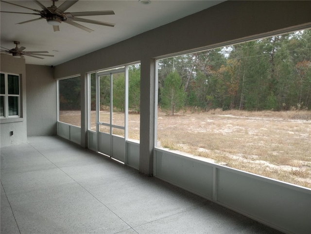 unfurnished sunroom with ceiling fan