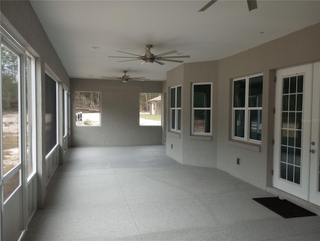 unfurnished sunroom with ceiling fan