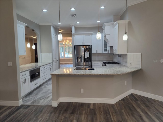 kitchen featuring white cabinets, hanging light fixtures, dark hardwood / wood-style floors, stainless steel fridge, and kitchen peninsula